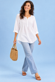 Blouse blanche en coton à col rond et patte de boutonnage plissée | Vue en mouvement | Lounelle Paris